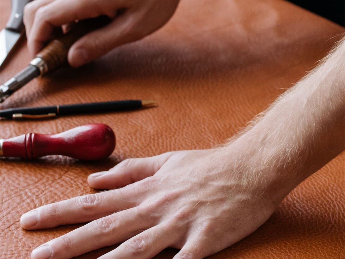 A craftsman marking out a finished tan leather hide